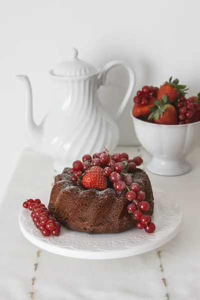 Chocolate cake with fresh berries set in a white tableware
