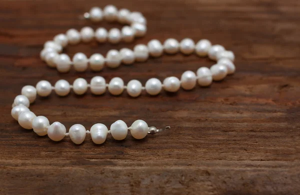 Pearls string wooden table closeup shallow DOF