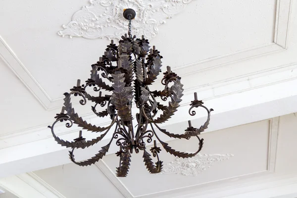 Antique chandelier hanging from white ceiling