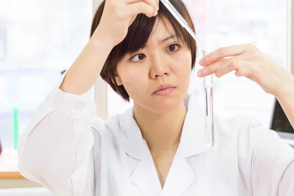 Asian female scientist with test tube