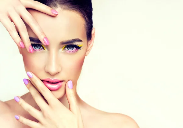 Woman with colourful makeup and  pink nails