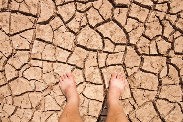Naked human bare feet on dry soil