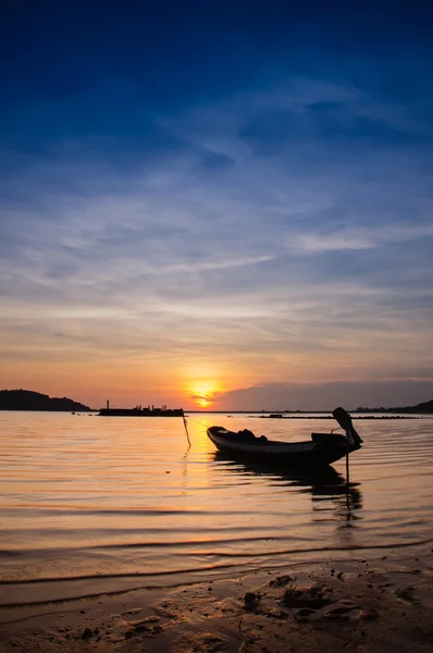 Beautiful silhouette fishing boat in lake at Twilight sky.