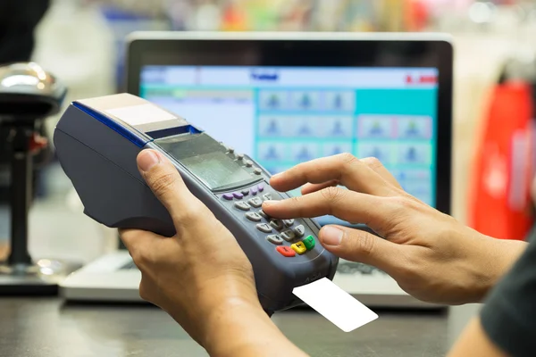 Man's hand with credit card swipe through terminal for sale in s