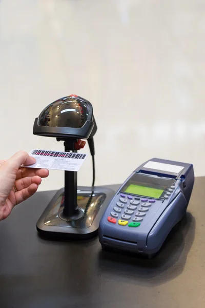 Cashier hand scanning barcode on member card