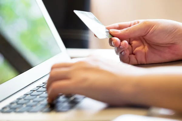 Woman holding credit card on laptop for online shopping concept