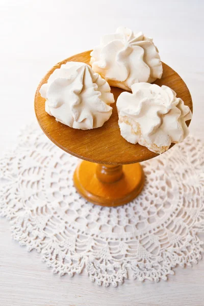 Meringue cookies on the wooden cake stand. Natural lights.