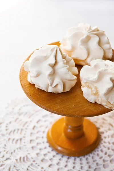 Meringue cookies on the wooden cake stand. Natural lights.