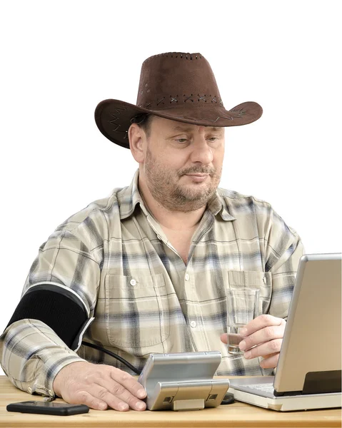 Cowboy in brown hat measures blood pressure