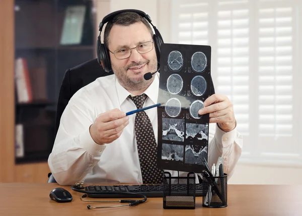Telehealth male doctor reviewing brain x-rays