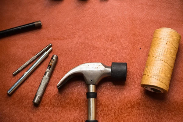 Leather crafting tools on work table.