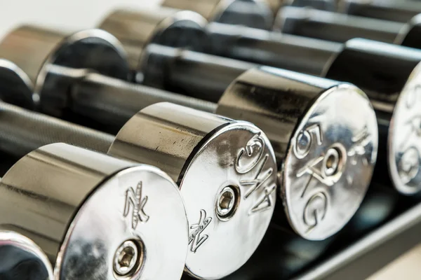 Dumbbells weight training equipment in gym close up