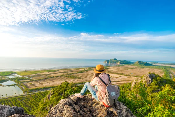 Hiker woman with camera enjoy the view at sunrise mountain peak