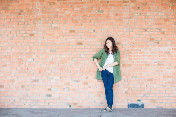 Gorgeous asian woman portrait over a brick wall
