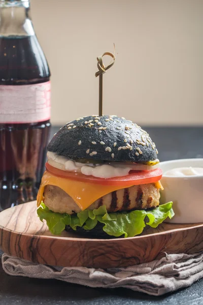 Black burger with grilled chicken patty