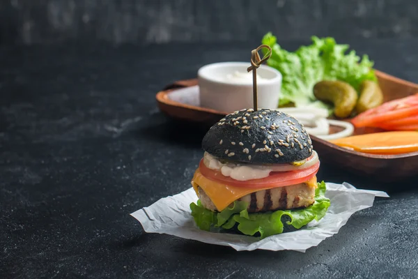 Black burger with grilled chicken patty
