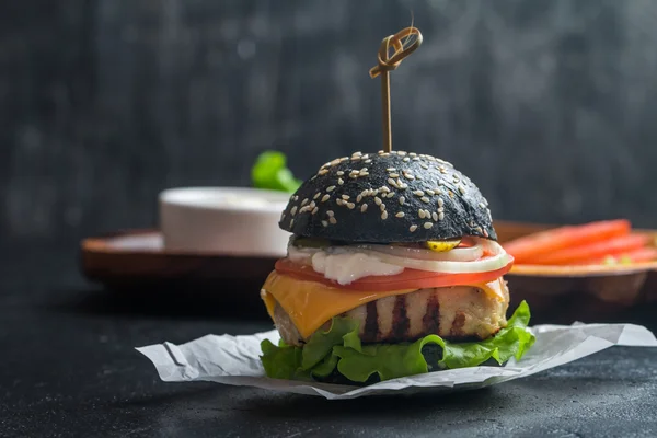 Black burger with grilled chicken patty