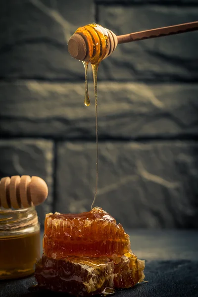 Honey dripping from a wooden honey dipper