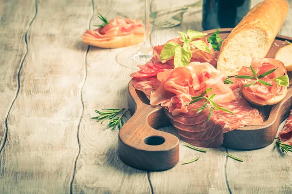 Concept of italian food with red wine, melon and prosciutto
