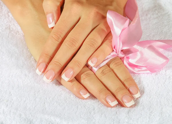 French manicure with pink and red hearts on the nails.