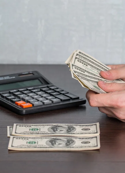 Man's hands with money and calculator