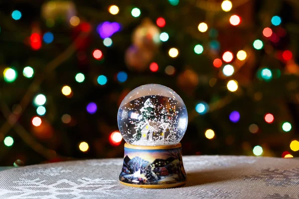 Christmas Snow Globe in front of Christmas tree lights
