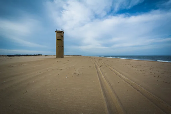 Tire tracks on the beach and a World War II Observation Tower at