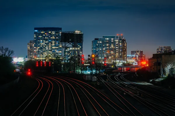 View of a rail yard and modern buildings at night, from the Bath