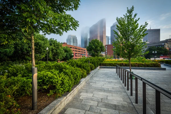 Walkway and gardens at North End Park with view of buildings in