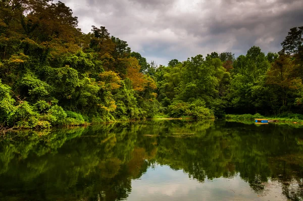Trees and storm clouds reflecting in a pond in York County, Penn