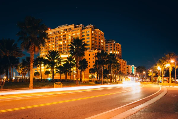 Traffic moving past a hotel and palm trees on Coronado Drive at