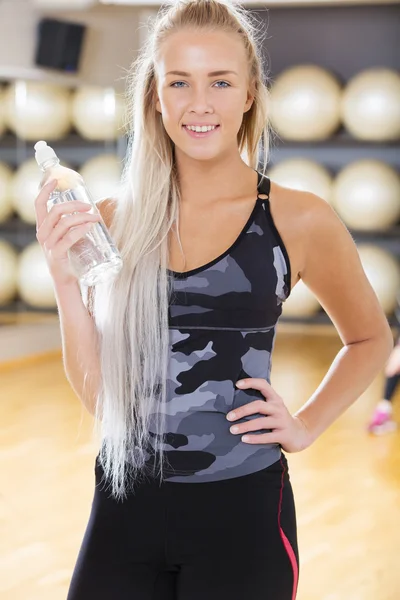 Smiling fitness woman in workout outfit at the gym