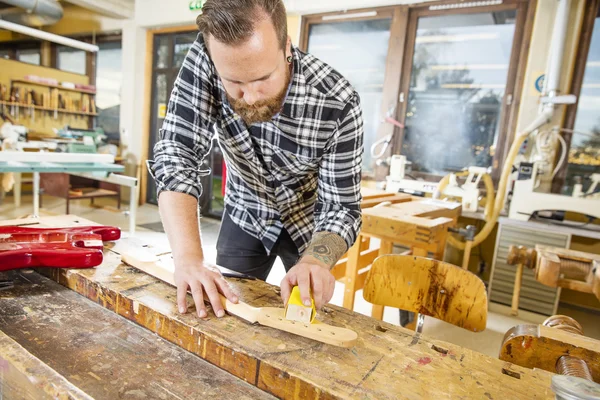 Carpenter works with musical instruments in workshop