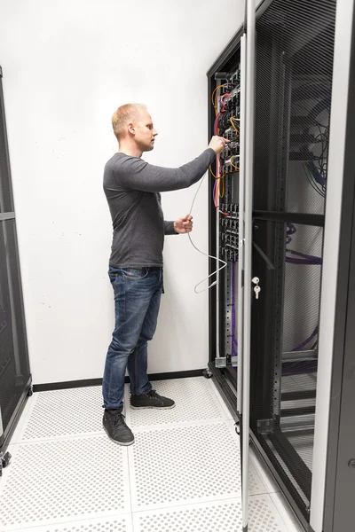 IT consultant installs network rack in datacenter