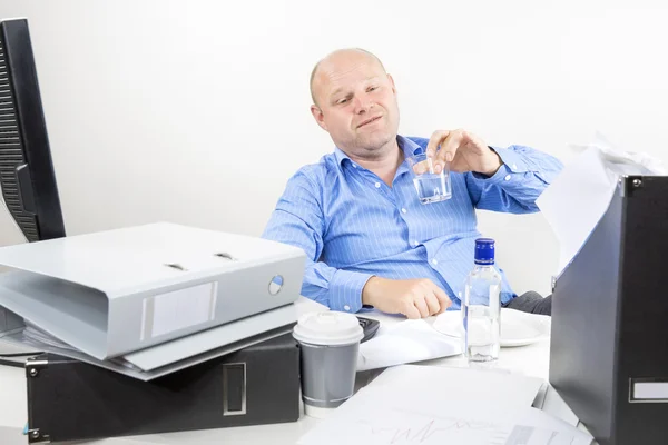Drunk businessman drinks alcohol at the office