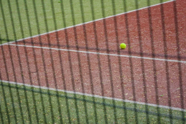 A tennis ball on the tennis court.