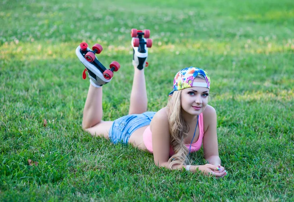 Girl on vintage roller skates lying on the grass