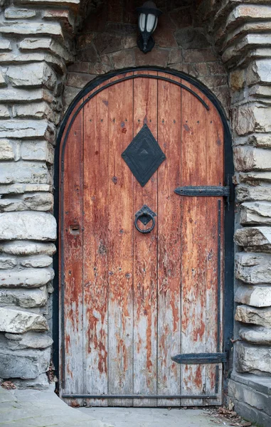 Old wooden door with wrought iron handle-beater