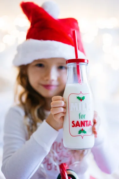 Cute baby girl in chritmas costume with milk jar