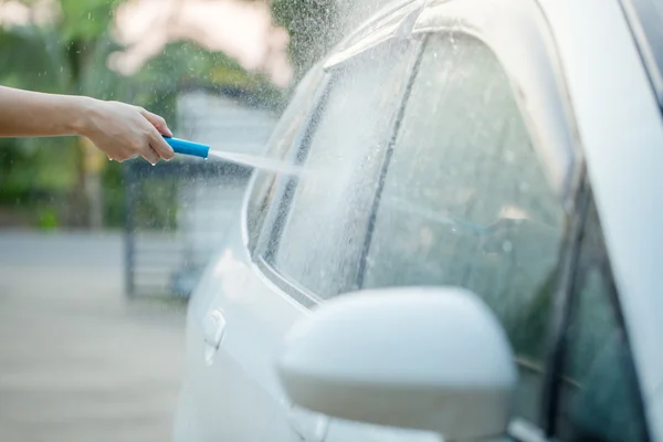 People cleaning car using high pressure water