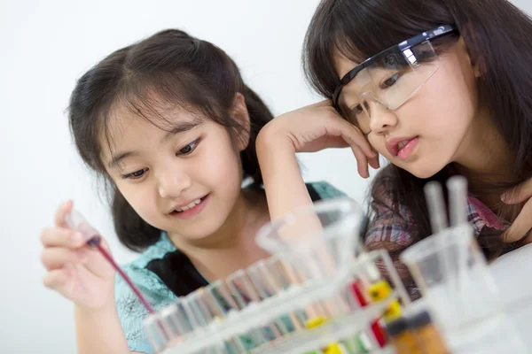 Little Asian student girl making science experiment in the laboratory class