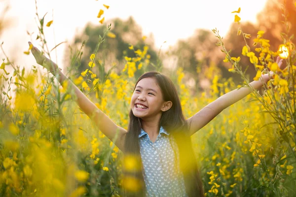 Happy Asian girl feeling freedom in the flower field
