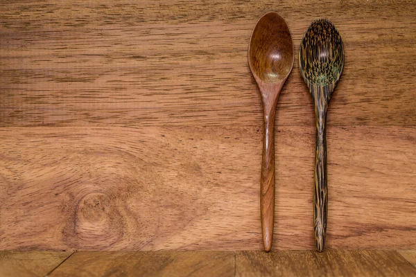 Wood spoon on wood background dark brown.