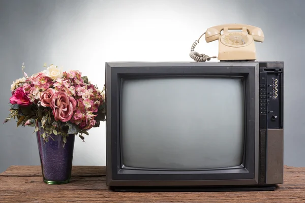 Vintage Television with old telephone on wood table