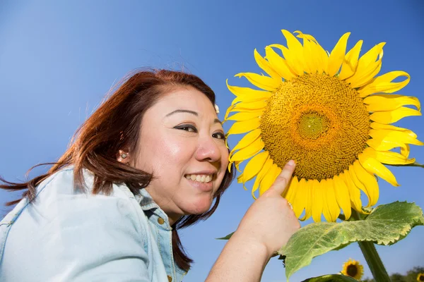 Happy asian woman in sunflower flower field.