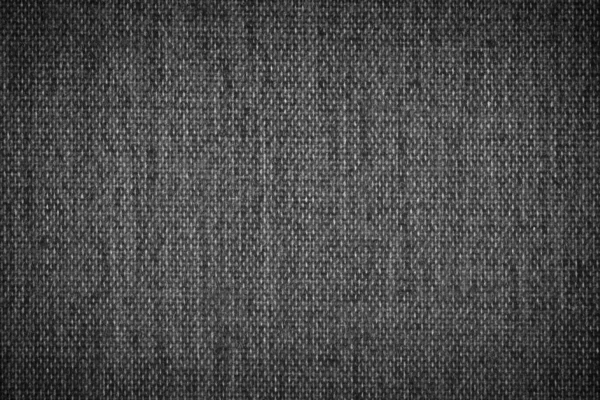 Background texture of dark black and white fabric closeup with vignette