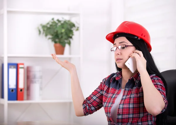 Woman engineer talking on the phone in the office