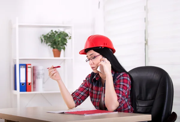 Woman engineer talking on the phone in the office