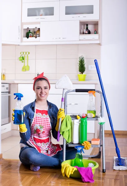 Woman with cleaning supplies in the kitchen