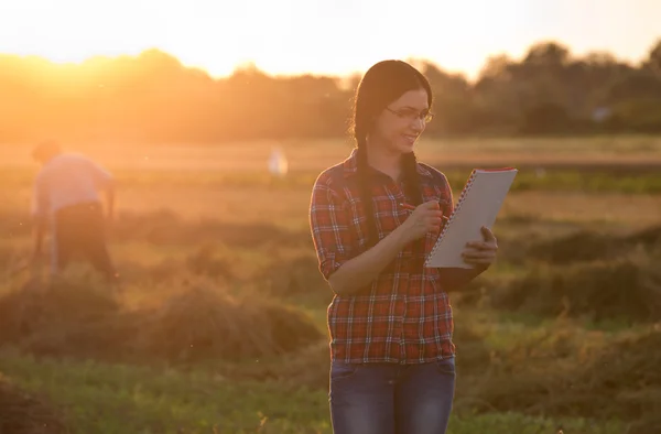 Farmer girl in field at sunset